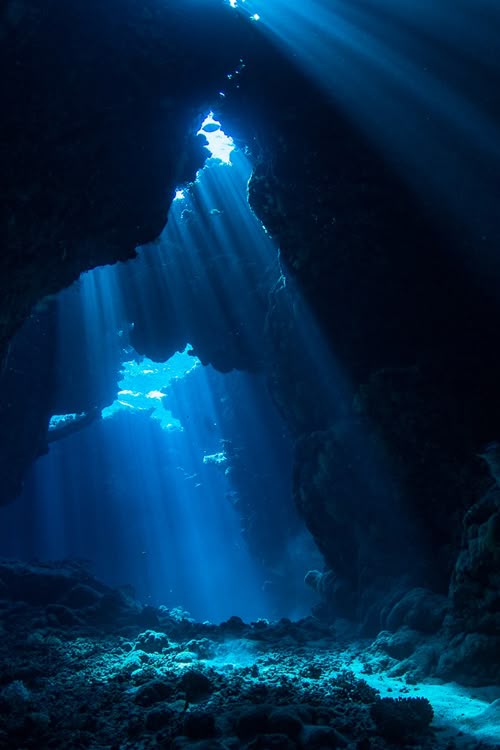 Diepe zee met lichtstralen die vanaf het wateroppervlak naar de zeebodem schijnen